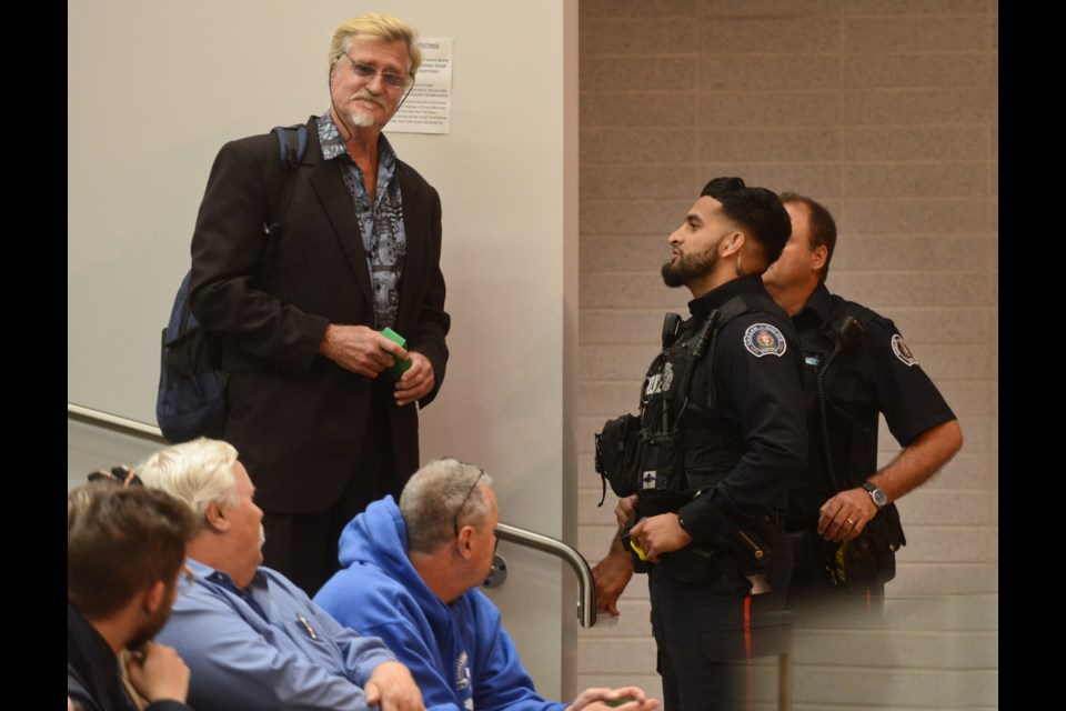 Independent candidate Kornelis Klevering, who was there as an observer, is escorted out of the room by Guelph Police at Wednesday's federal election debate because he was handing out literature regarding an upcoming all-candidates meeting. Tony Saxon/GuelphToday