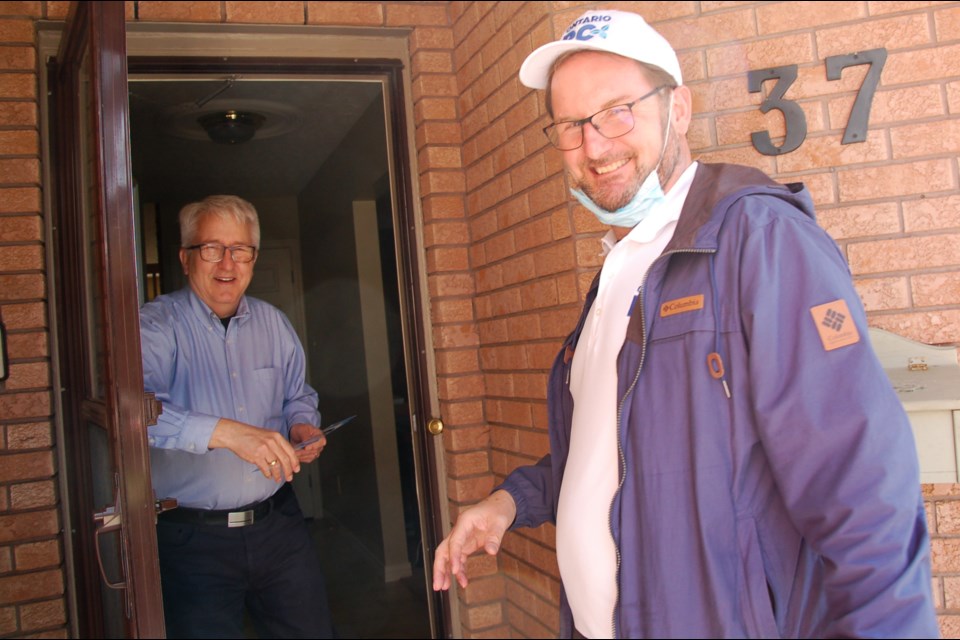 Progressive Conservative candidate Peter McSherry, right, knocked on the door of Jim Baker during door-to-door campaigning earlier this month.