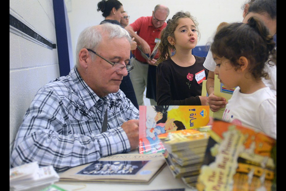 Robert Munsch signs some of his books that have been translated into Arabic for immigrant children Saturday, Sept. 17, 2016, at Westwood Public School. Tony Saxon/GuelphToday