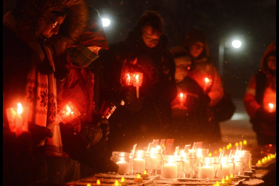 People file past the names and photos of women Thursday at a vigil at Marianne's Park that was part of National Day of Remembrance and Action on Violence Against Women. Tony Saxon/GuelphToday