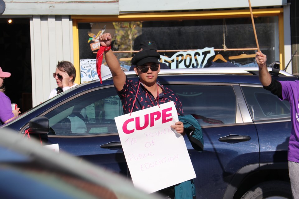 CUPE-OSBCU frontline education workers picket in front of Mike Schreiner's office.