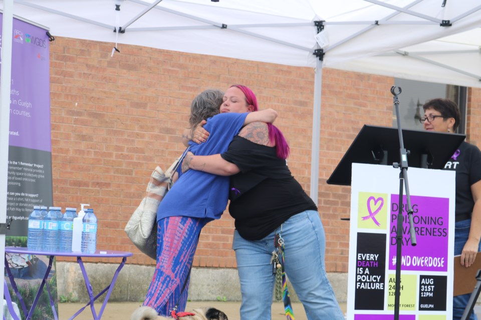 Cory Gillies and Karen Lomax hug following Lomax's speech during the Drug Awareness event Thursday in Mount Forest.
