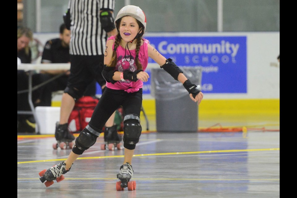 A player smiles after racking up
some points at the first ever junior girls roller derby match in Guelph Saturday at the Victoria Road Rec Centre. Tony Saxon/GuelphToday