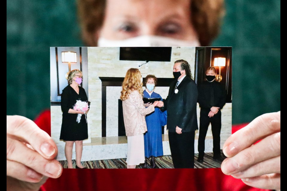 Guelph minister Jay Brown holds up a photo of her marrying Tom and Diane P in a small ceremony in Cambridge in August 2020. Ariel Deutschmann/GuelphToday