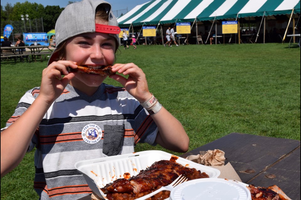 Kiana Kurtz digs into a plate of delectable ribs at the 19th annual Ribfest Guelph, on all weekend in Riverside Park. (Rob O'Flanagan/GuelphToday)