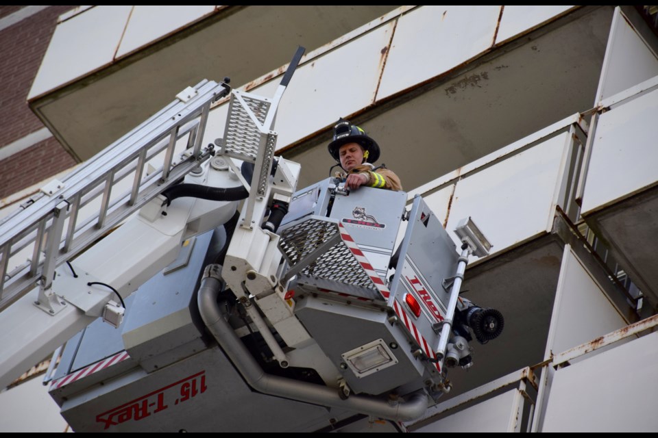 A firefighter was hoisted to a seventh floor balcony of the Park Mall Apartments Thursday. A small fire cleared the building of most residents.