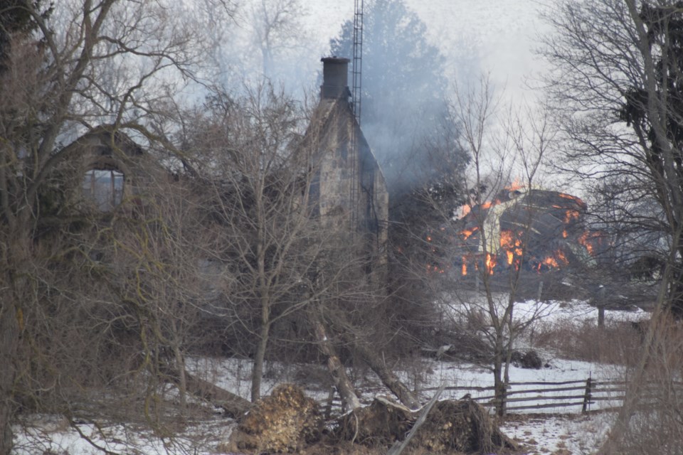 Flames were still visible from the road as an empty farmhouse and barn burned Friday morning along Township Road 3. Rob O'Flanagan/GuelphToday