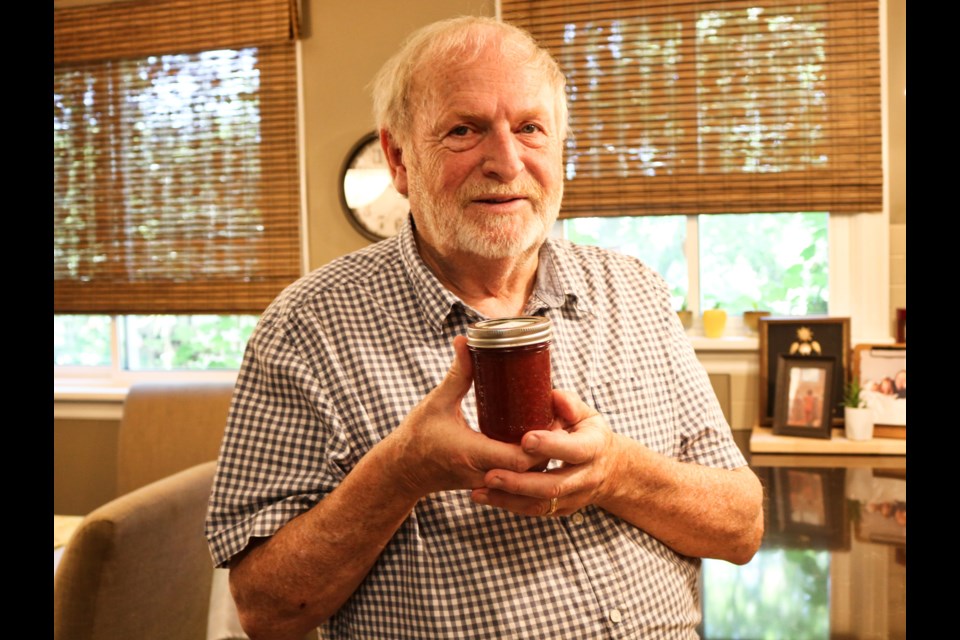 Rick Westgarth holding up a jar of homemade jam. 