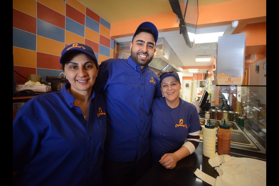 Layla Dinkha, left, with her son Joseph Eeshw and friend Karol Easha on the opening day Monday, May 8, 2017, of Guelph's newest downtown eatery, Osmow's on Wyndham Street. Tony Saxon/GuelphToday