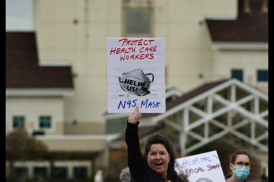 A health care worker holds a sign outside St. Joseph's Health Centre on Thursday during a rally calling for pandemic pay and better safety equipment for all workers. Tony Saxon/GuelphToday