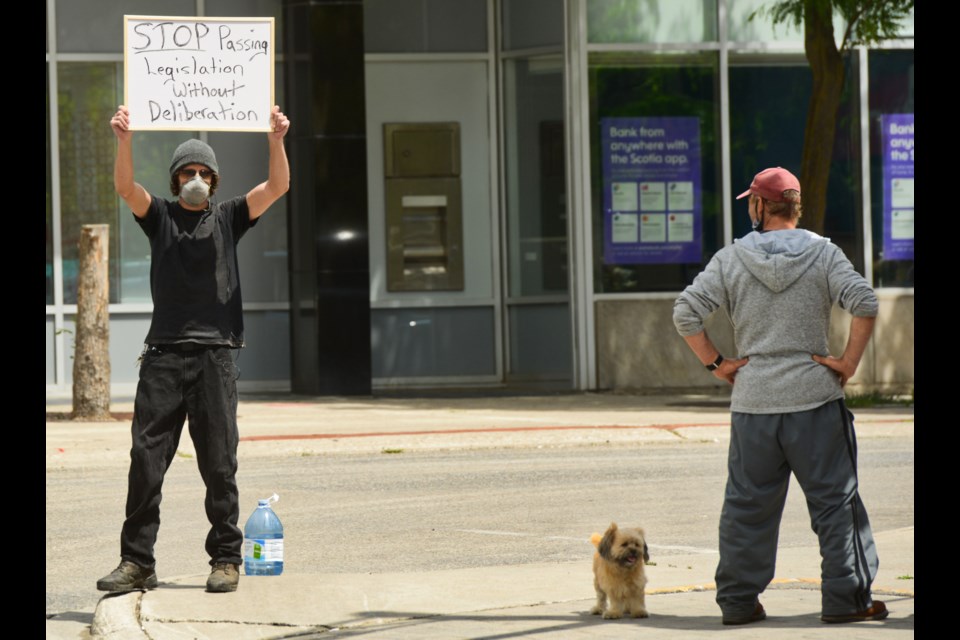 A man holds a sign as 15 people gathered Wednesday in Downtown Guelph protesting the provincial government's new Bill 175. Tony Saxon/GuelphToday