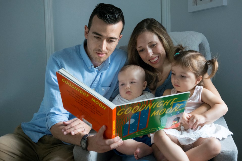 Kevin Page and Meaghan Forestell-Page read Goodnight Moon with their daughter Mae and two-month-old Sam. Every newborn in Guelph receives the book as part of the Born to Read program. Kenneth Armstrong/GuelphToday