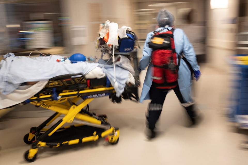 A paramedic moves a COVID-positive patient from the intensive care unit in Guelph to another hospital for care. Kenneth Armstrong/GuelphToday