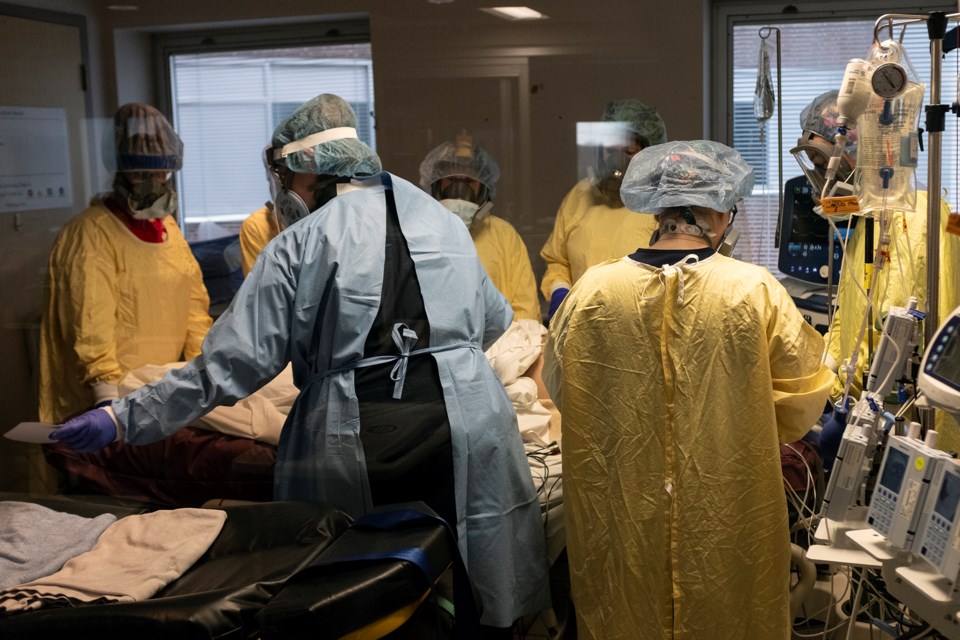 Six hospital staff members and two paramedics (in blue) work for an hour to safely move a patient on a ventilator. The delicate procedure involved transferring the tubes from the hospital's ventilator to a portable unit on the stretcher. Kenneth Armstrong/GuelphToday