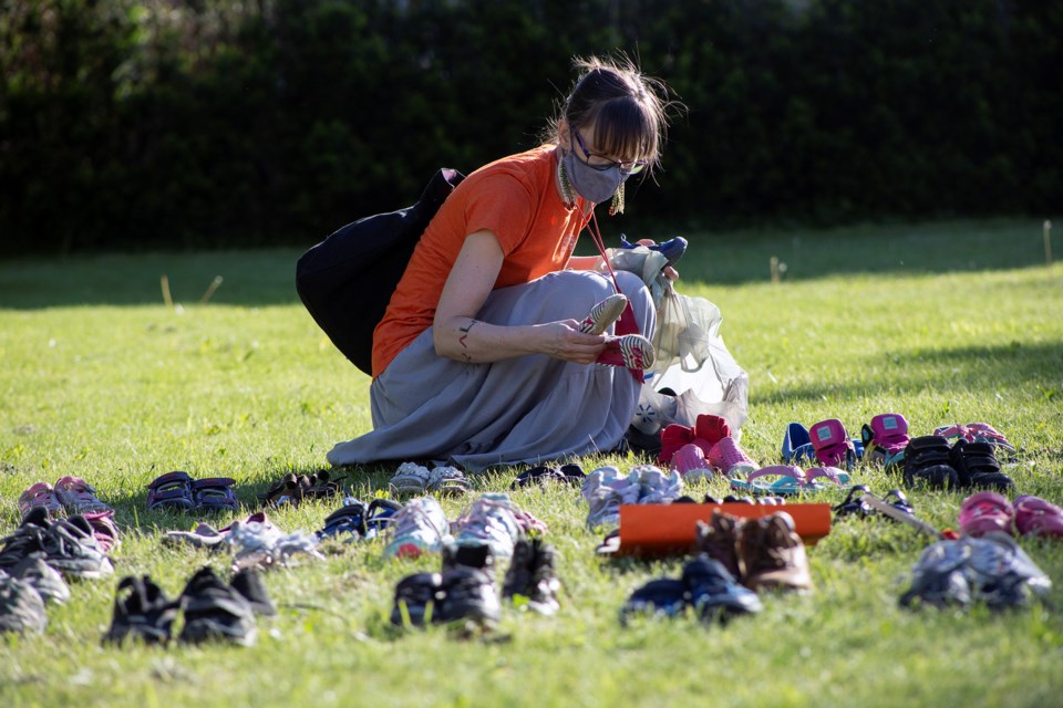 A woman lays shoes on the lawn of Basilica of Our Lady in remembrance of the remains of 215 children fund recently at the grounds of a former residential school in B.C. Kenneth Armstrong/GuelphToday