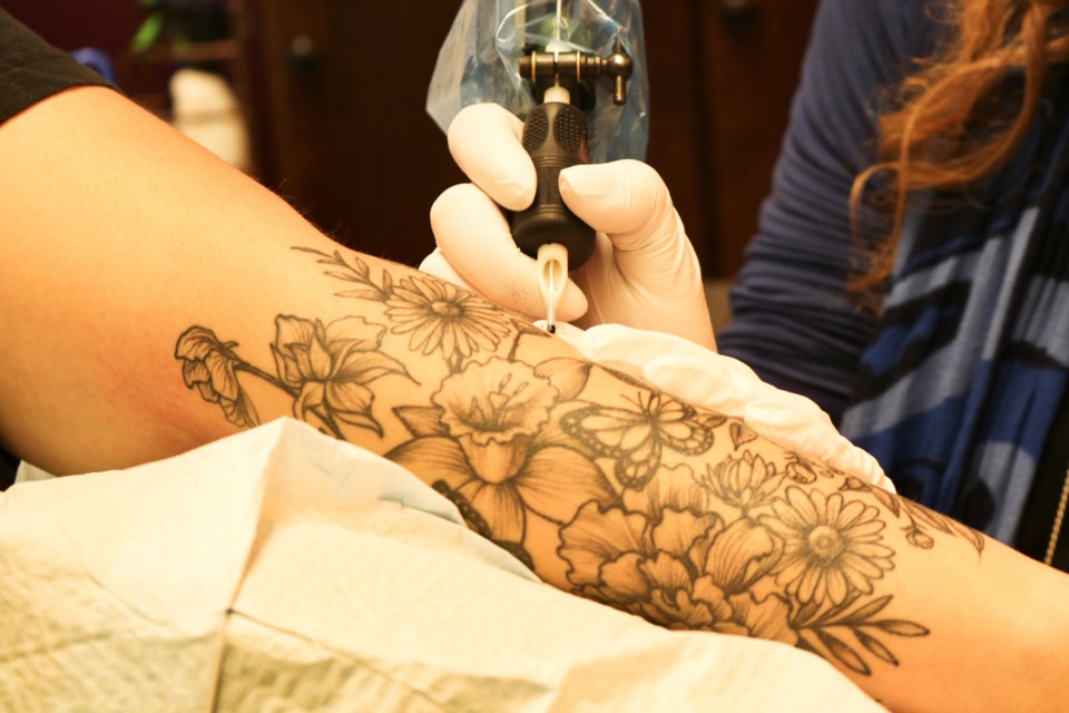 Stewart touching up a client's tattoo. Ariel Deutschmann/GuelphToday