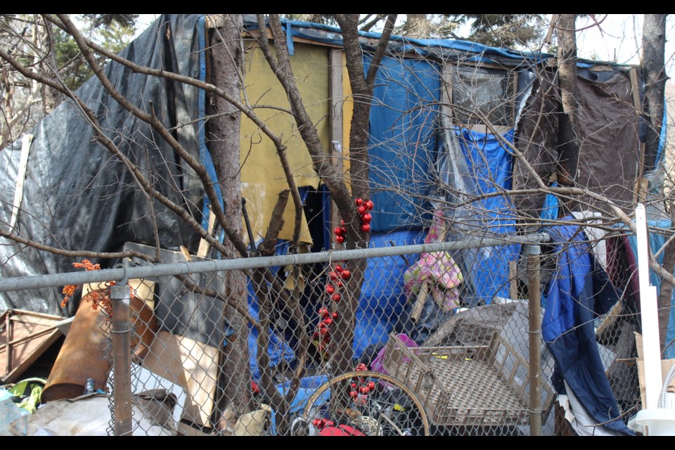 A full view of the structure set up at the encampment, made of wood and tarp, built about a year ago according to one of the men living there.