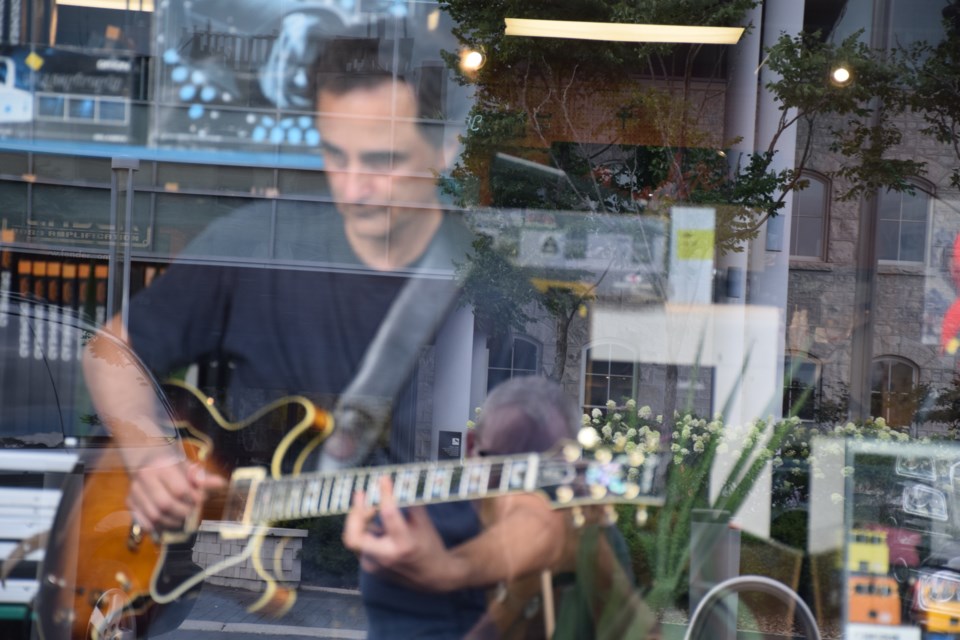 A guitar player tries out a new axe at Guelph Music, Carden Street. 