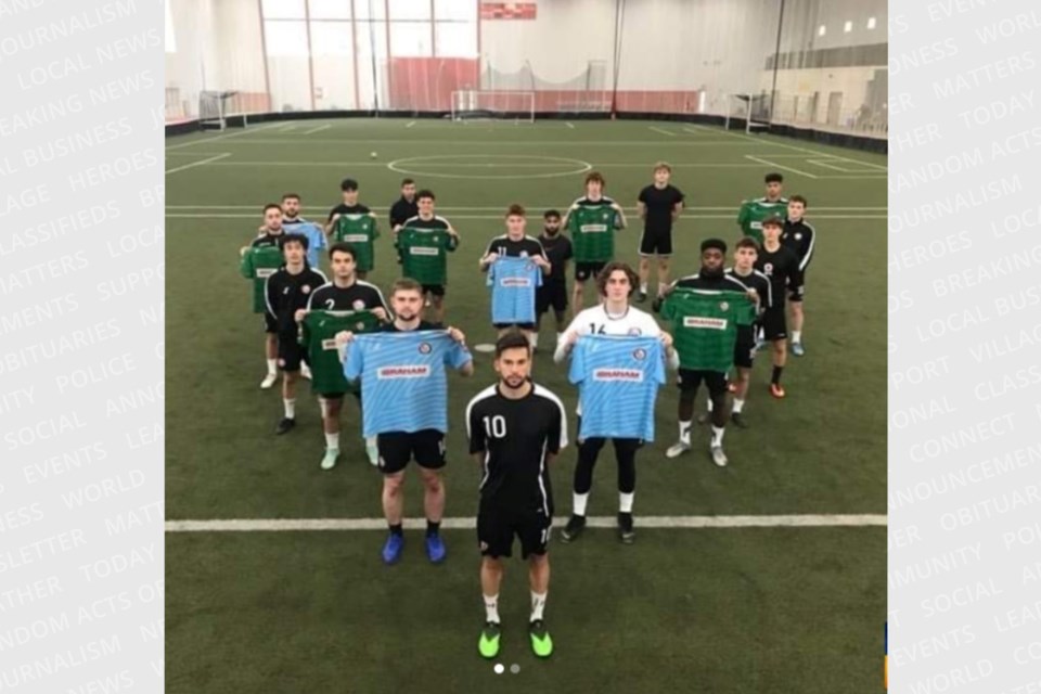 Guelph United soccer players form a heart on the pitch while holding up Svyatik Artemenko's goalkeeper jerseys.