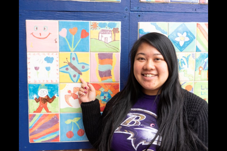 Julie Ratsavong points to a mosaic tile she contributed to Shelldale Family Gateway in 2008 when she was a teenager. Ratsavong began attending Shelldale programs at the age of five and now works as a nurse while still volunteering at the centre. Kenneth Armstrong/GuelphToday