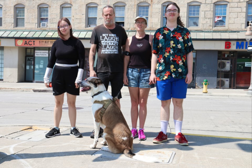 Wayne Matthews, Lettie Jones and their two kids, Isis (left) and Cyrus (right) stand outside the Stationview Apartments with their dog Baxter. 