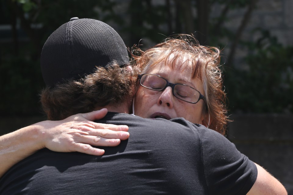 Sharon Tanti, mother of murder victim Nick Tanti, hugs a supporter immediately after the release on bail of the second of two brothers charged inheritance son's death. Kenneth Armstrong/GuelphToday