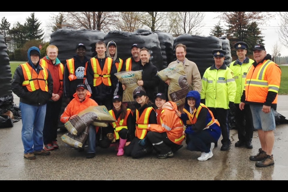 It was a soggy but dedicated group of volunteers at the Mulch Sale at the Centre Wellington Sportplex. Those in attendance included Centre Wellington Mayor Kelly Linton and Wellington Halton Hills MPP Ted Arnott (centre, standing), and Wellington County OPP Inspector Scott Lawson, (front row, kneeling).