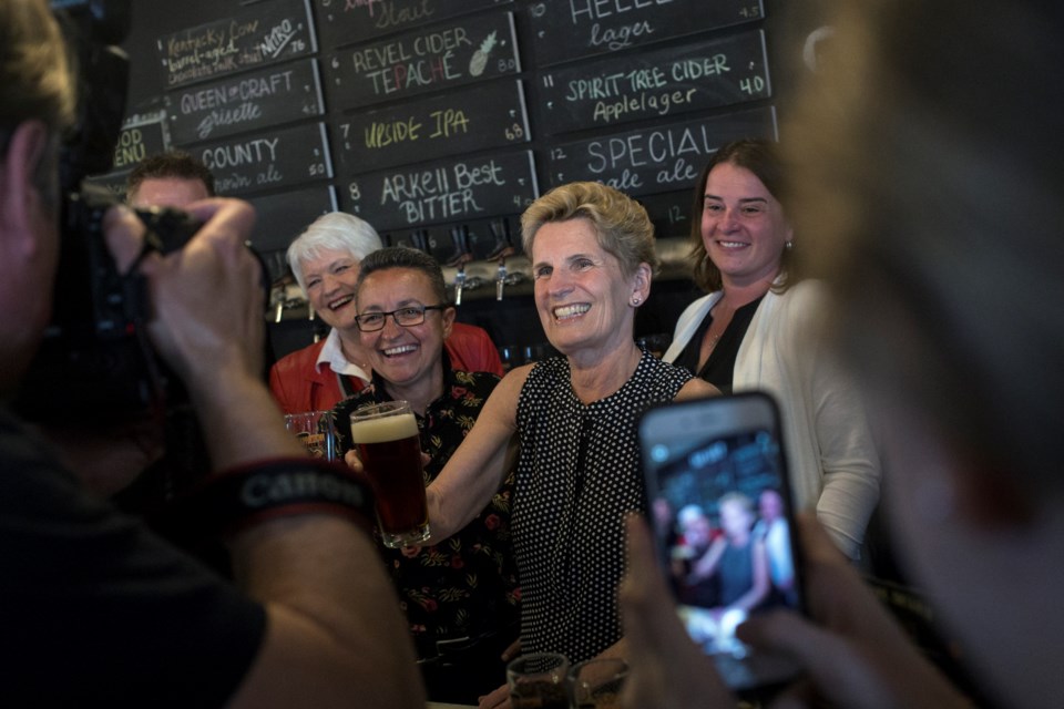 Liberal leader Kathleen Wynne poses with a draught beer during a campaign event Tuesday at Wellington Brewery. Kenneth Armstrong/GuelphToday