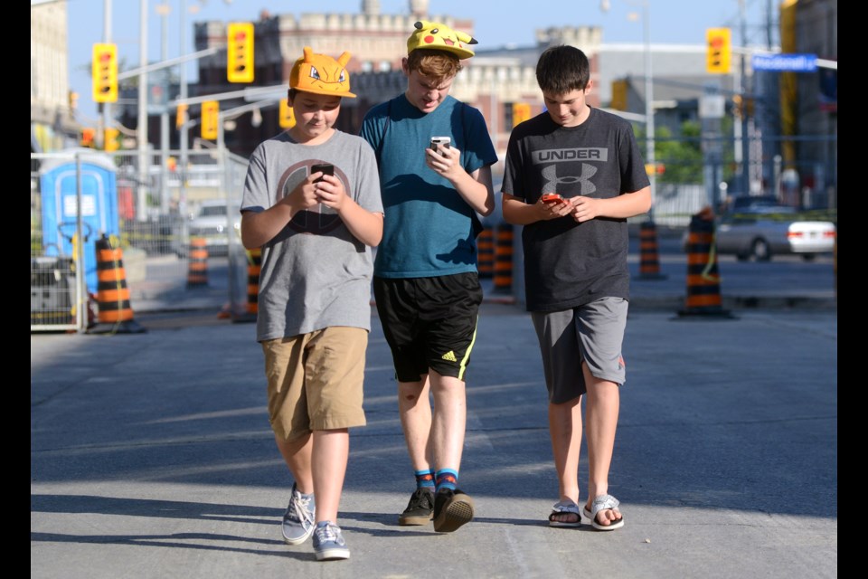 Friends Jacob Downer, Cade Meloche and Max Coleman play Pokemon Go in downtown Guelph Wednesday, July 12, 2016. Photo Tony Saxon/GuelphToday