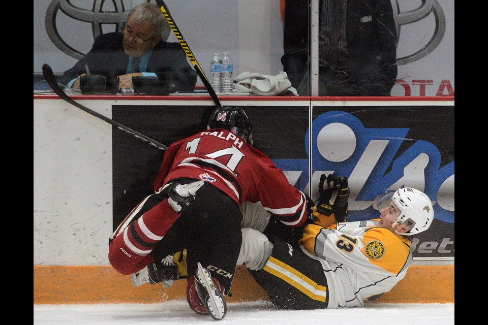 Cedric Ralph of the Guelph Storm hits the Sarnia Sting's Brady Hinz into the boards Friday, March 17, 2017, at the Sleeman Centre. Tony Saxon/GuelphToday