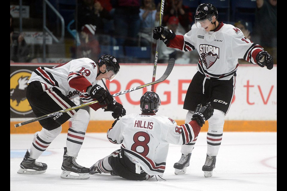 Guelph Storm teammates Isaac Ratcliffe, left, and Alexey Toropchenko, right, help Cam Hillis celebrate his first OHL goal Saturday, Oct. 7, 2017, at the Sleeman Centre. Tony Saxon/GuelphToday
