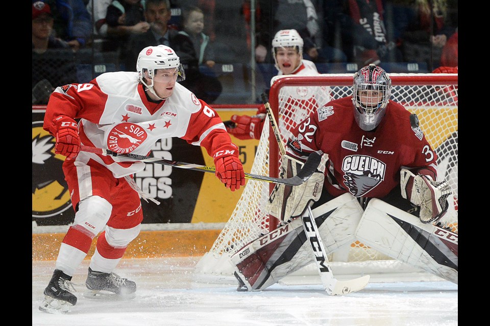 The Soo Greyhounds Rasmus Sandin, left, and Guelph Storm goaltender Anthony Popovich keep their eye on a puck Sunday, Jan. 7, 2018. at the Sleeman Centre. Tony Saxon/GuelphStorm