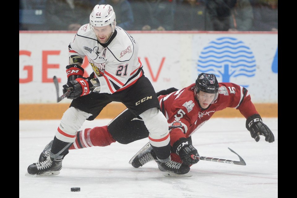Dmitri Samorukov of the Guelph Storm dives to try and poke the puck away from Jonah Gadjovich. Tony Saxon/GuelphToday