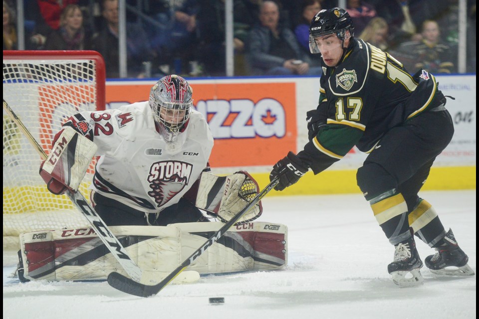 London's Nathan Dunkley goes for a loose puck in front of Guelph Storm goaltender Anthony Popovich Tuesday, March 7, 2018, in London. Tony Saxon/GuelphToday