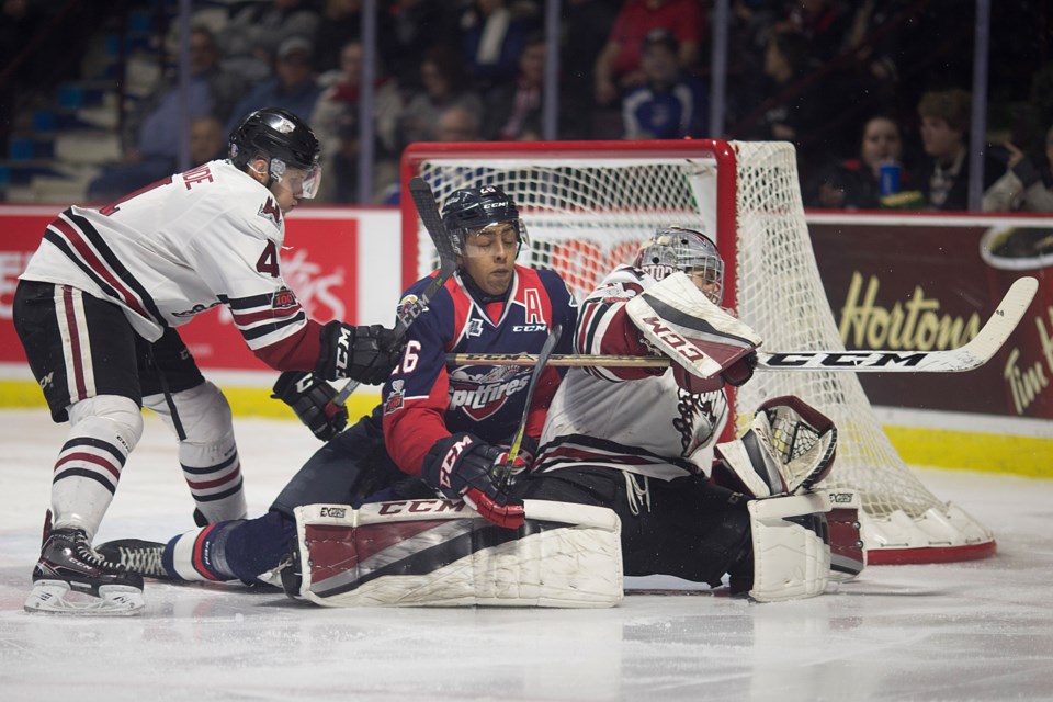 Cole Purboo of the Windsor Spitfires gets tied up with Guelph Storm goaltender Anthony Popovich and defenceman Owen Lalonde Thursday in Windsor. Dax Melmer/Windsor Star