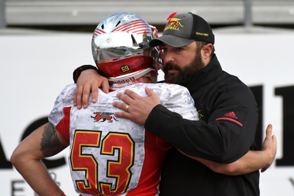 Head coach Kevin MacNeill of the Guelph Gryphons and linebacker Luke Korol embrace following Guelph's semifinal loss to the Western Mustangs Saturday at London. Rob Massey for GuelphToday