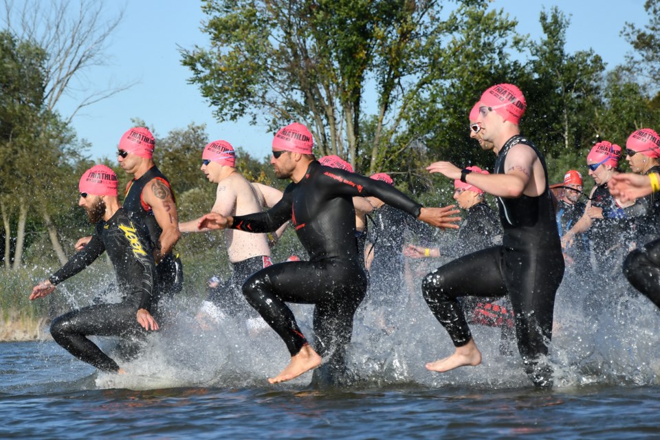 Competitors in the second wave dash into Guelph Lake to start the swim leg of Saturday's Guelph Two sprint triathlon at the Guelph Lake Conservation Area. Rob Massey for GuelphToday