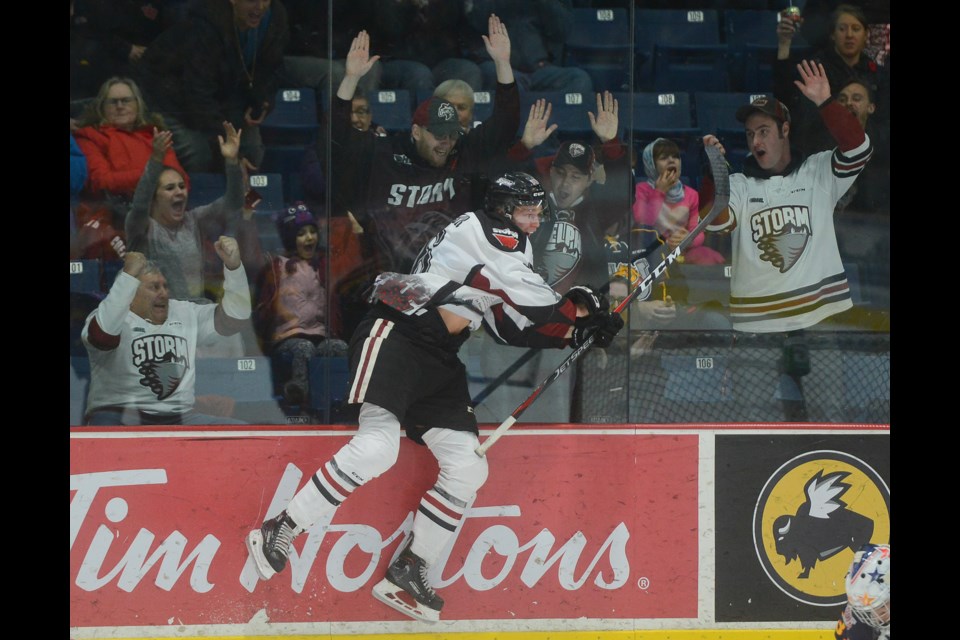 Nate Schnarr leaps against the glass in celebration of his third goal Friday at the Sleeman Centre against the Barrie Colts. Tony Saxon/GuelphToday