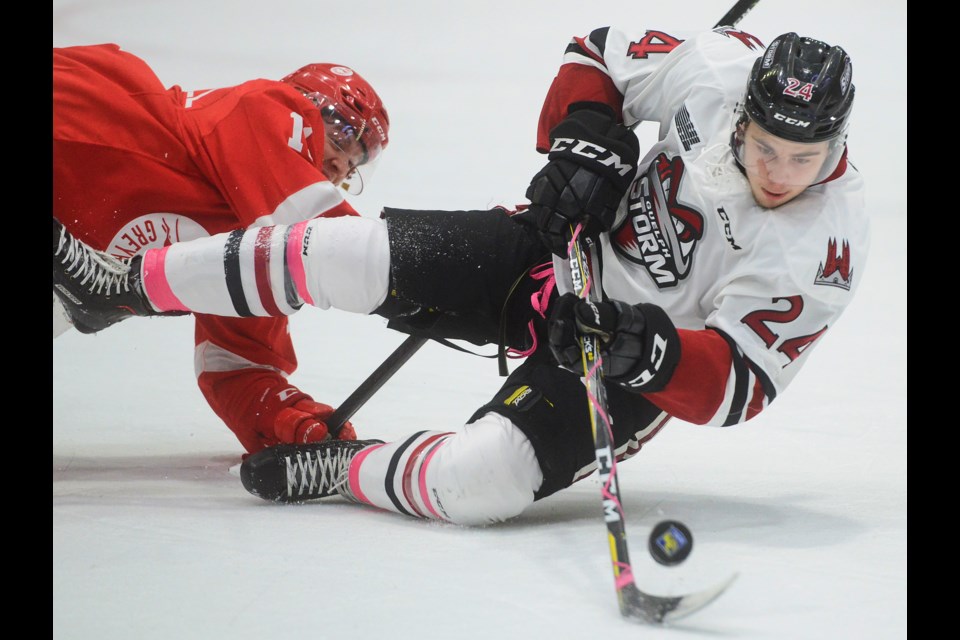 The Guelph Storm's Tag Bertuzzri gets knocked down by a SaultStoe. Marie Greyhounds player. Tony Saxon/GuelphToday