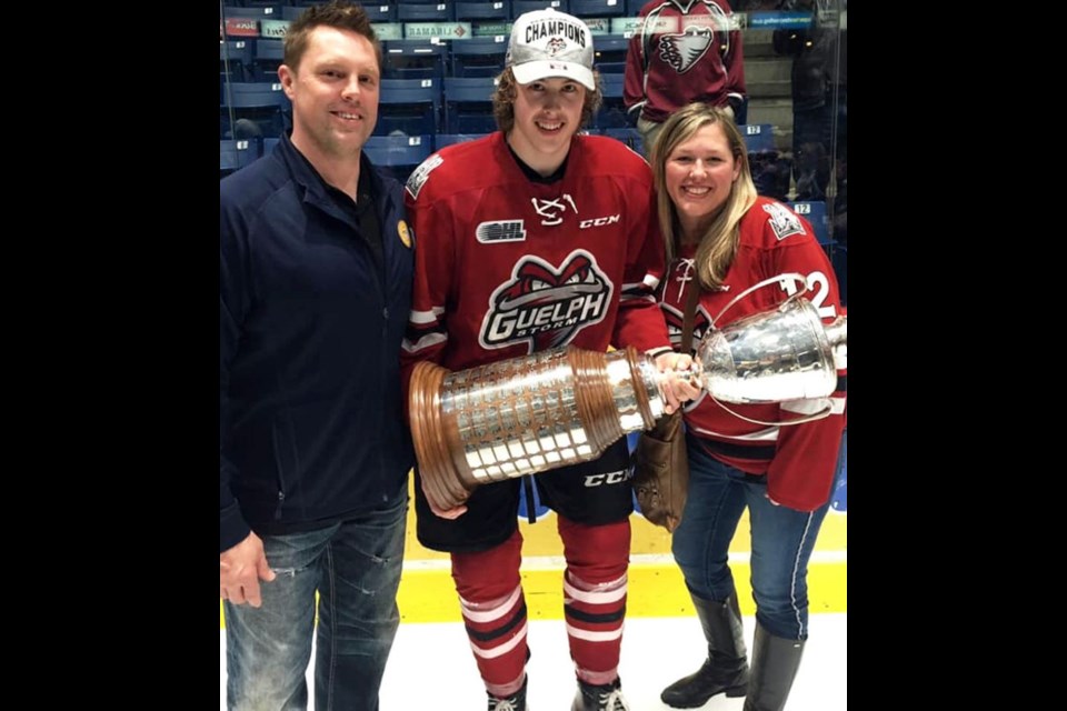 Keegan Stevenson poses with the OHL championship trophy with dad Jeremy and mom Selena. Family photo