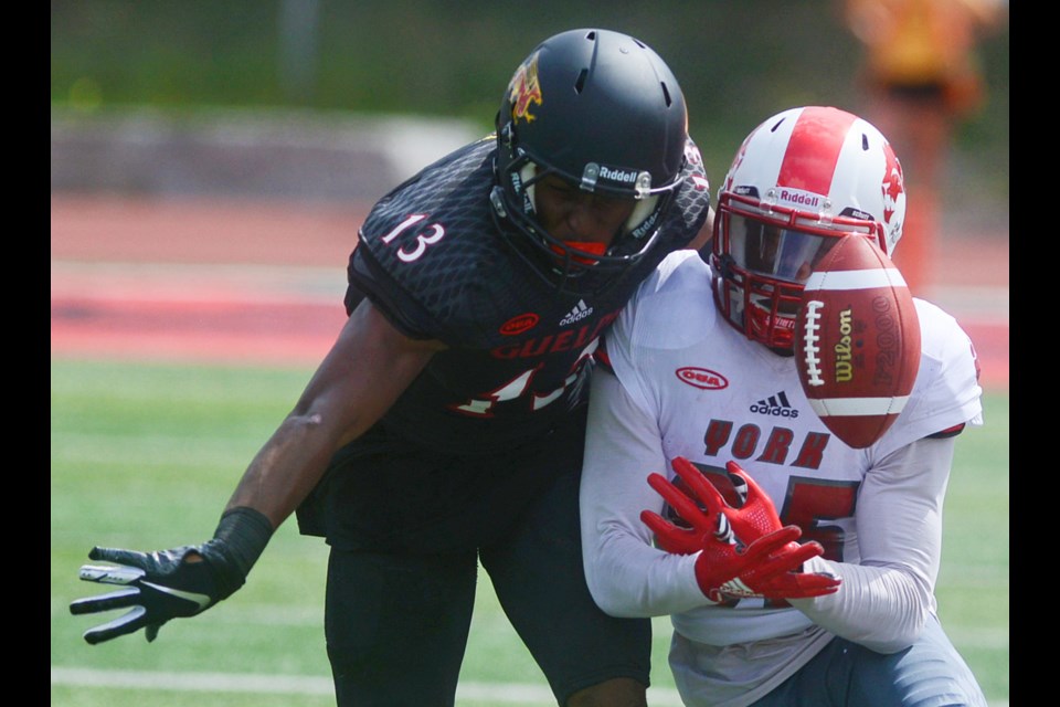 Akeem Knowles, left, of the Guelph Gryphons knocks he ball away from York Lions receiver Alex Daley Monday at Alumni Stadium. Tony Saxon/GuelphToday