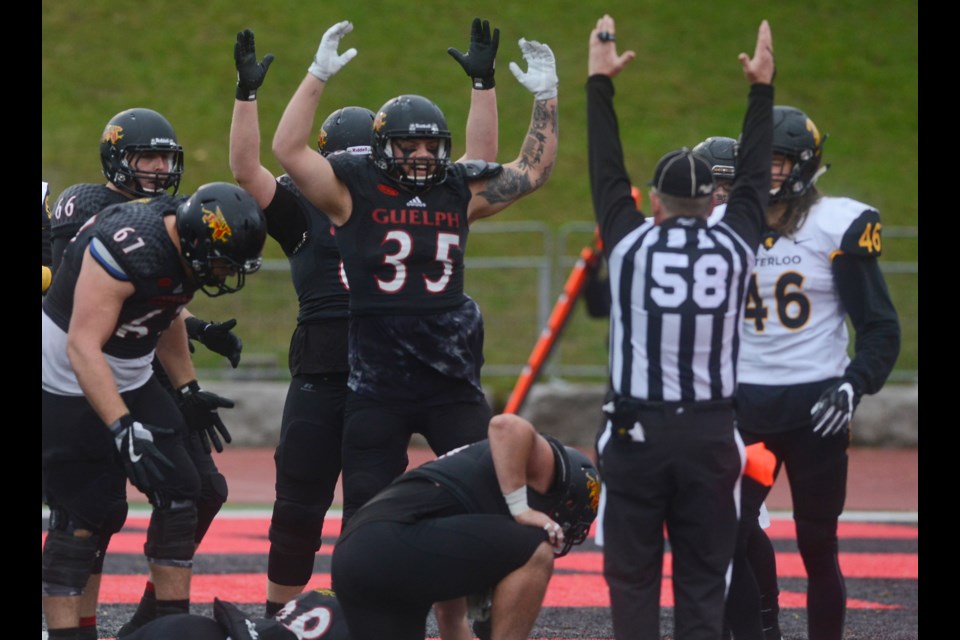 Members of the Guelph Gryphons give the official a hand in signalling a touchdown Saturday at Alumni Stadium against the Waterloo Warriors. Tony Saxon/GuelphToday