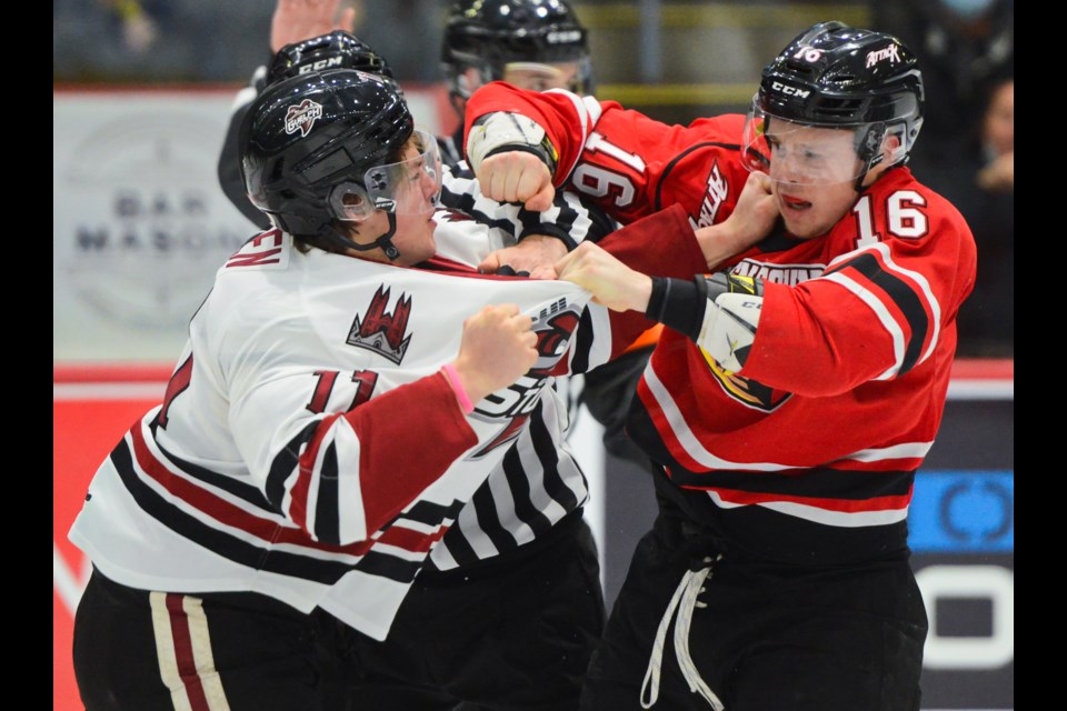 Guelph Storm defenceman Cam Allen, left, fights with Owen Sound Attack forward Logan Lesage during OHL action at the Sleeman Centre Friday night.