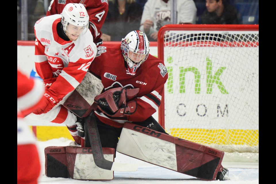 Tye Kartye of the Soo Greyhounds looks for a rebound in front of Guelph Storm goaltender Jacob Oster Tuesday at the Sleeman Centre.