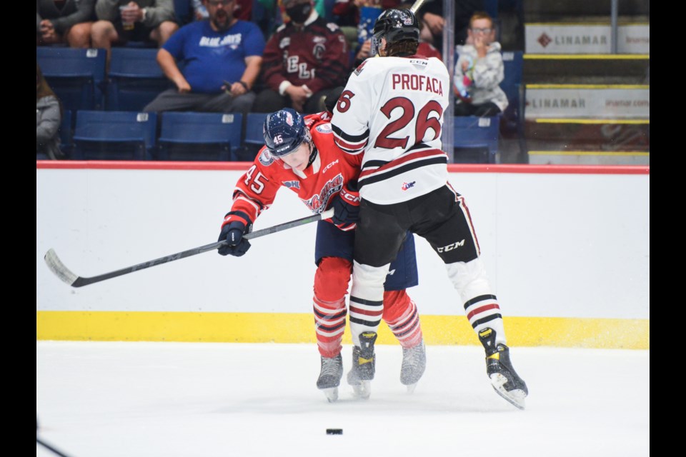 The Guelph Storm's Luka Profaca hits an Oshawa Generals player in open ice Friday at the Sleeman Centre during OHL pre-season action.