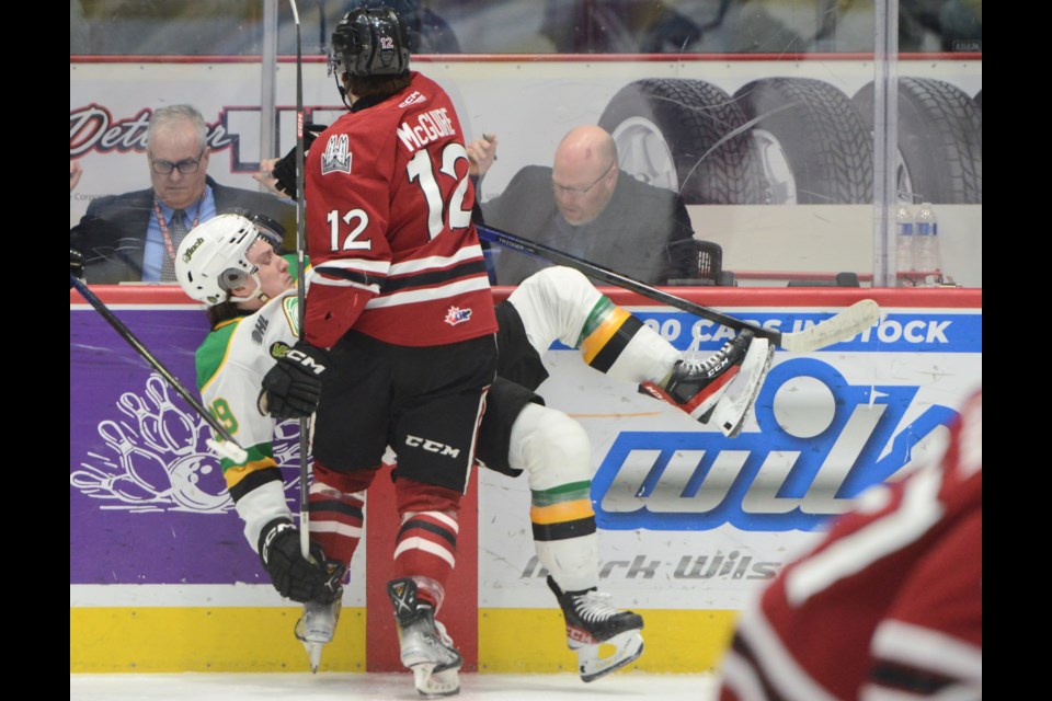 The Guelph Storm's Ryan McGuire checks London's Max McCue along the boards Saturday at the Sleeman Centre.