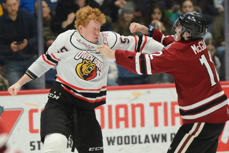 Owen Sound's Madden Steen fights the Guelph Storm's Ryan McGuire in the second period Monday at the Sleeman Centre.