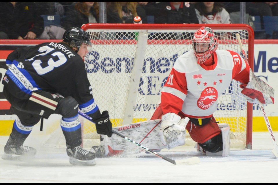 Guelph's Charlie Paquette is stopped in close by Soo goaltender Charlie Schenkel.