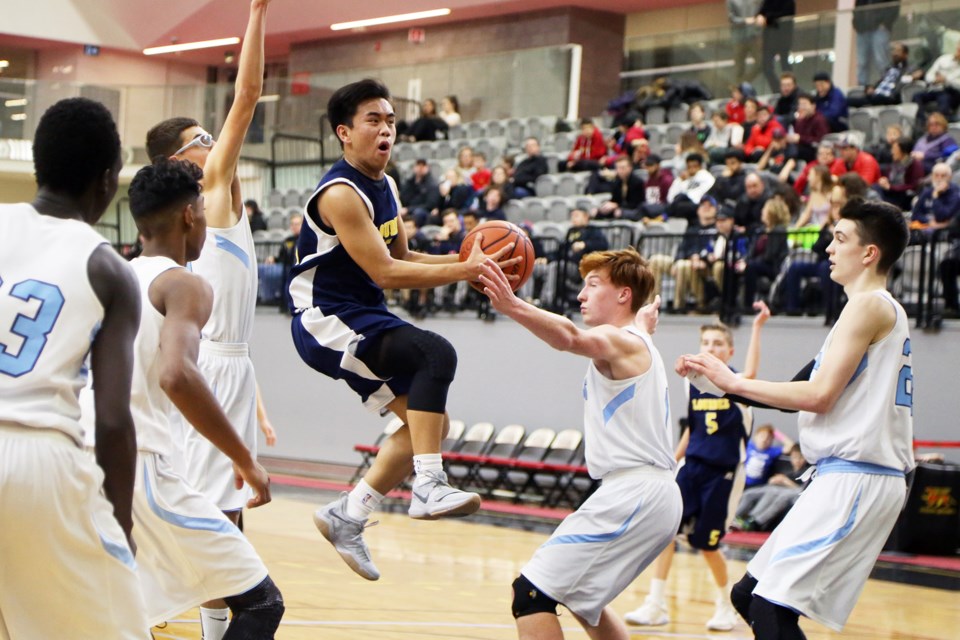 Lourdes Crusaders' Kevin Martinez goes airborne with the ball under pressure by all five Ross Royals players during the District 10 junior boys championship game Saturday. Kenneth Armstrong/GuelphToday