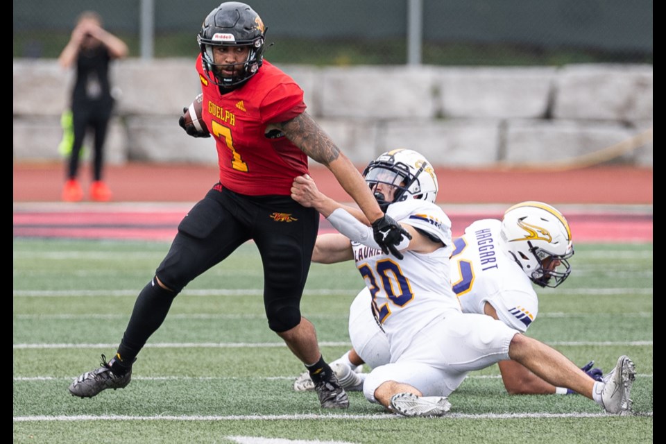 Kaine Stevenson of the Guelph Gryphons escapes the grasp of a Laurier defender.